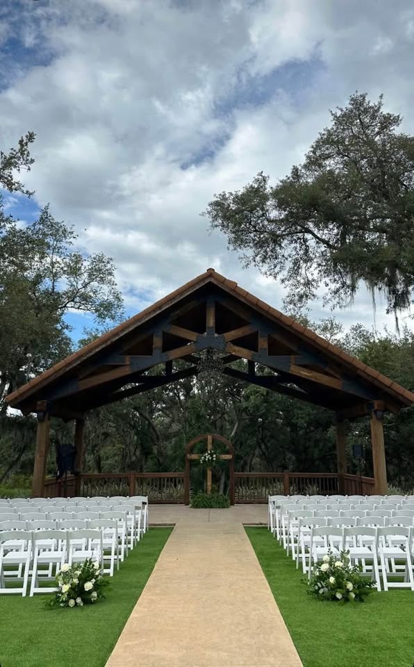 Elegant wooden cross with floral arrangement at ceremony